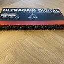 Černý rackový audio interface s červeným horním panelem. Na spodní straně je nápis ULTRAGAIN DIGITAL AUDIOPHILE 8 IN/8 OUT ADAT AUDIO INTERFACE MODEL…
