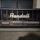 Černý kytarový zesilovač s mřížkou v horní části, na které je bílé logo Randall. Na ovládacím panelu jsou nápisy RH300, 300W TUBE/MOSFET VALVE-DYNAMI…