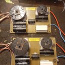 Dvě podobné elektronické desky s osazenými součástkami. Na deskách jsou černé válcové kondenzátory s nápisy BENNIC XPP 15.0uF 5% 160VAC/250VDC a BENN…