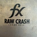Detailní záběr na povrch kovového činele s matným, šedohnědým povrchem. Na povrchu je černý nápis „fx“, pod ním text „RAW CRASH“ a dále „LARGE BELL“.…
