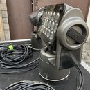 Dva černé LED reflektory s pohyblou hlavou umístěné v transportním kufru. Na boku jednoho z nich je čitelný nápis SGM. Povrch zařízení vykazuje známk…