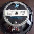Černý reproduktor s kovovým rámem a magnetem. Na magnetu je bílá nálepka s logy FANE a WHARFEDALE a textem: „FANE ACOUSTICS LTD SANDLEAS WAY LEEDS WE…