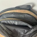 Černý textilní pouzdro s rukojetí, ve kterém jsou uloženy dva kovové činely zlatavé barvy. Činely jsou umístěny v oddělených přihrádkách pouzdra. Na…