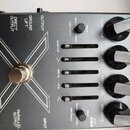 Detailní pohled na ovládací panel šedého elektronického zařízení. Na povrchu jsou nápisy OUTPUT, GROUND LIFT, DIRECT OUTPUT a PARALLEL OUTPUT. V pros…