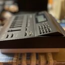 Černý digitální klavír nebo syntetizátor s klávesnicí a ovládacím panelem s displejem a tlačítky. Na levé straně je viditelné logo KORG. Povrch příst…