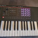 Černý MIDI kontrolér s klávesnicí a ovládacím panelem. Na panelu je nápis SYNTH CTRL, sekce SEQUENCER a mřížka 16 podsvícených čtvercových padů s čís…