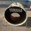 Bílá basová bubna s černým předním koženem, na kterém je bílý nápis YAMAHA. Nástroj je umístěn na kovovém stojanu a má chromovanévypážky a šrouby. Po…