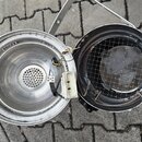 Fotografie zachycuje dvě rozebrané části kovového reproduktoru v stříbrné barvě. Levá část tvoří hliníkový kón s perforovaným středem a připojenými e…