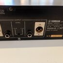 Záběr na zadní panel černého elektronického zařízení. Jsou zde vidět dva XLR konektory s nápisy CH A a CH B, dva jack konektory a regulační šroubek u…