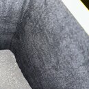 Detailní záběr na černý, texturovaný povrch z jemného textilního materiálu. V horní pravé části je vidět okraj bílého a žlutého prvku. Na fotografii…