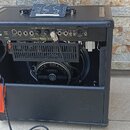 Černý kytarový kombozesilovač s otevřeným zadním panelem. Na horní části je nápis "MEAN TWEEN" a logo "MESA BOOGIE". V interiéru je viditelný reprodu…