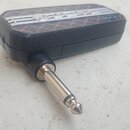 Černý obdélníkový modul s kovovým 6,35mm jack konektorem. Na horní straně je stříbrný dekorativní prvek s nečitelným logem a nápisem Metal. Povrch mo…