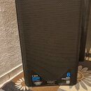 Černý reproduktor s kovovou mřížkou. V dolní části jsou nálepky s nápisy K12.2, 2000 WAT a 6 YEAR WARRANTY. Na spodním okraku je logo QSC a nápis K.2…