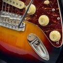 Detail elektrické kytary s korpusem v barevném přechodu od žluté přes červenou k černé. Nástroj má červený želvový pickguard, chromovaný kobylník a t…