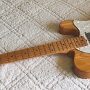 Elektrická kytara s přírodním dřevěným povrchem a hnědým hmatníkem. Na hlavě je nápis Greco, korpus má bílý perleťový pickguard a jeden f-otvor. Nást…