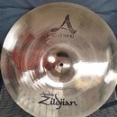 Kovový činel s viditelným broušením povrchu. Na číneli jsou nápisy A CUSTOM, CRASH 16" a Avedis Zildjian. Povrch je v dobrém stavu bez viditelných po…