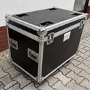 Černý transportní case s hliníkovými hranami a rohovými zpevněními. Na boku jsou dvě kovové rukojeti a na přední straně jeden zámek. Na pravém boku j…