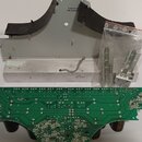 Fotografie zobrazuje sadu náhradních dílů, která zahrnuje zelenou printed circuit board (PCB) s připájenými součástmi a černými válcovitými elementy.…
