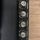 Detail ovládacího panelu kytarového zesilovače v černé barvě. Panel obsahuje pět otočných knoflíků s nápisem OLD №7 BRAND a popisky POST, REVERB, BAS…