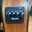 Detail ovládacího panelu elektroniky na dřevěné akustické kytáře. Na černém plastovém panelu je nápis AEQ2T a logo Ibanez. Panel obsahuje čtyři ovlád…