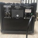 Zadní strana černého kytarového komba. Na přístroji jsou vidět nápisy JOYO, JOYO TECHNOLOGY CO. LTD, www.joyoaudio.com a Digital Guitar Amplifier Mod…