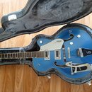 Modrá polodublová elektrická kytara v černém kufru. Na krytu snímačů je nápis GRETSCH a na hmatníku u mostku nápis FilterTron. Kytara má stříbrný Big…