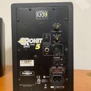 Zadní strana černého studiového monitoru značky KRK SYSTEMS. Na přístroji je nápis ROKIT POWERED 5 RPG2 a ovládací prvky HF LEVEL ADJUST a VOLUME. Vs…