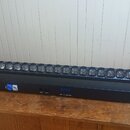 Černý LED lineární reflektor s řadou kulatých čoček v horní části. Na spodním panelu jsou umístěny konektory pro napájení a DMX, digitální displej s…