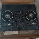 Černý DJ kontrolér značky Numark s nápisem PARTY DJ CONTROLLER. Uprostřed je uveden model PARTY MIX LIVE. Zařízení obsahuje dva jog-wheels, několik p…