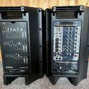 Dvě černé plastové aktivní reproduktory z pohledu zezadu. Levý reproduktor má na zadním panelu schéma zapojení a nápisy YAMAHA STAGEPAS 500. Pravý re…