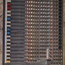 Šedočerný míchací pult s červeným rámem. Na spodní hraně je bílý nápis ALLEN & HEATH a označení modelu ZED 22FX. Zařízení obsahuje řadu posuvníků s b…