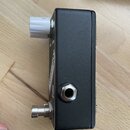 Černý kytarový efekt v kovovém šasi s bílým plastovým knoflíkem. Na boku je vidět jeden vstupní/výstupní konektor 6,35 mm jack. Na horní straně jsou…