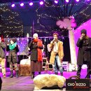 Fotografie zachycuje pět zpěváků na osvětleném pódiu v zimním oblečení. V pravém dolním rohu je vidět logo s nápisem CHOrizzo very funny acappella. V…