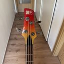 Fotografie zachycuje hlavu basové kytary s červeno-žlutým přechodem barvy. Na hlavě je bílý nápis „SDGR“ a pod ním menší text „SOUNDGEAR BY Ibanez“.…