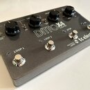 Šedý efekt pedál s nápisy DITTO X4 LOOPER a tc electronic. Zařízení má čtyři ovládací knoflíky, čtyři stomečovací spínače a několik malých kontrolníc…