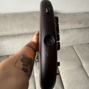 Detailní pohled na hranu tmavě hnědého trupu elektrického nástroje. Jsou vidět vstup pro kabel a otvor pro šroub s vnitřním zapuštěním. Povrch laku v…
