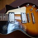 Elektrická kytara s trupem v barevné gradaci od černé přes hnědou po žlutou. Nástroj má dva snímače typu humbucker, bílý pickguard a čtyři ovládací k…
