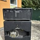 Zadní strana kytarového zesilovače a reproboxu v černé barvě. Na horní části je bílý nápis Bogner a ovládací prvky s označením PARALLEL FX LOOP. Spod…