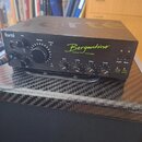 Černý zesilovač s nápisem Bergantino AUDIO SYSTEMS. Na předním panelu jsou ovládací prvky: velký knoflík Master, čtyři knoflíky ekvalizéru (Bass, LoM…