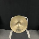 Kruhové činely z mosazného kovu s viditelným broušením povrchu. Na spodní části je čitelné logo Zildjian. V centru se nachází malý bílý štítek s neči…