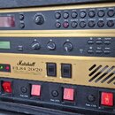 Sada tří rackových zařízení značky Marshall v zlatém provedení. Horní jednotka je Valve MIDI Pre-Amp JMP-1, prostřední Signal Processor JFX-1 a spodn…