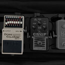 Tři efektové pedály umístěné vedle sebe v černém pouzdře. První pedál je bílý s nápisy Bass Equalizer GEB-7, OUTPUT a INPUT. Prostřední pedál je čern…
