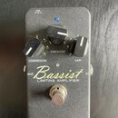 Černý kytarový pedál s nápisem Bassist LIMITING AMPLIFIER a žlutým podpisem Rlhmberg ve spodní části. Obsahuje tři černé ovládací knoflíky s popisky…