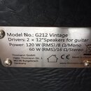 Detailní fotografie kovového štítku připevněného k černému povrchu z imitace kůže. Na štítku je text: „Model No.: G212 Vintage“, „Drivers: 2 x 12"Spe…