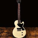Krémově bílá elektrická kytara s polodupým korpusem a černým pickguardem. Na hlavě hmatníku je žlutý nápis „Bunny“ a pod ním bílý nápis „Guitar Resea…