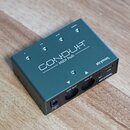 Tmavně zelený kovový MIDI hub s nápisem CONDUIT MIDI hub a logem strymon. Na horní straně jsou čtyři skupiny malých kontrolních LED diod. Na předním…