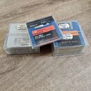 Tři průhledné plastové krabičky s disketami. Na disketách jsou vidět nápisy „Roland W-30 SYSTEM DISK“, „ZB61200“ a „SYS-KW30-6 Ver.1.00“. Na jedné z…