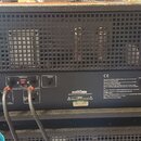 Zadní strana kytarového zesilovače v černé barvě s kovovou mřížkou. Na zadním panelu jsou viditelné nápisy „FX Send“, „FX Return“, „Direct Out“, „Lin…