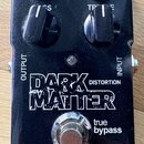 Černý efekt pedál s nápisy DARK MATTER DISTORTION, true bypass a tc electronic®. Na horní části jsou čtyři černé ovládací knoflíky, přepínač VOICE a…