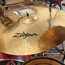 Zlatý činel s viditelným opracováním povrchu v podobě koncentrických rýh. Na povrchu je černý nápis Zildjian a v horní části menší, méně čitelný nápi…